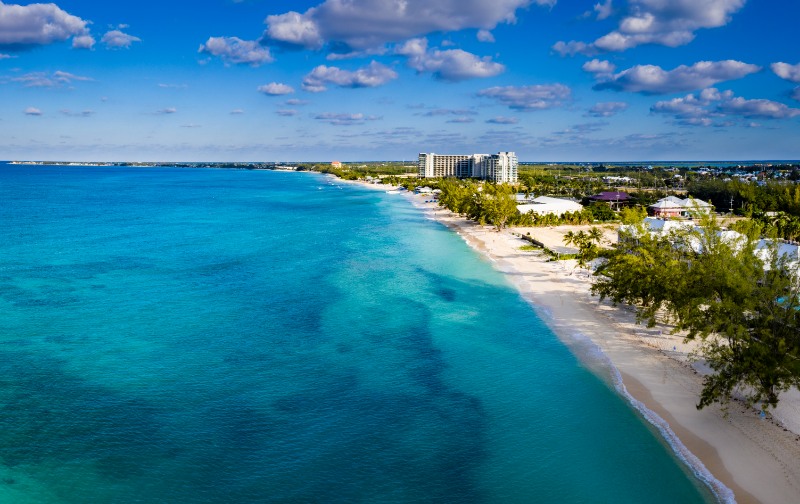 Aerial panorama of the cayman islands and grand cayman over seven mile beach in the turquoise and deep blue water of the caribbean sea during a clear bright summer morning