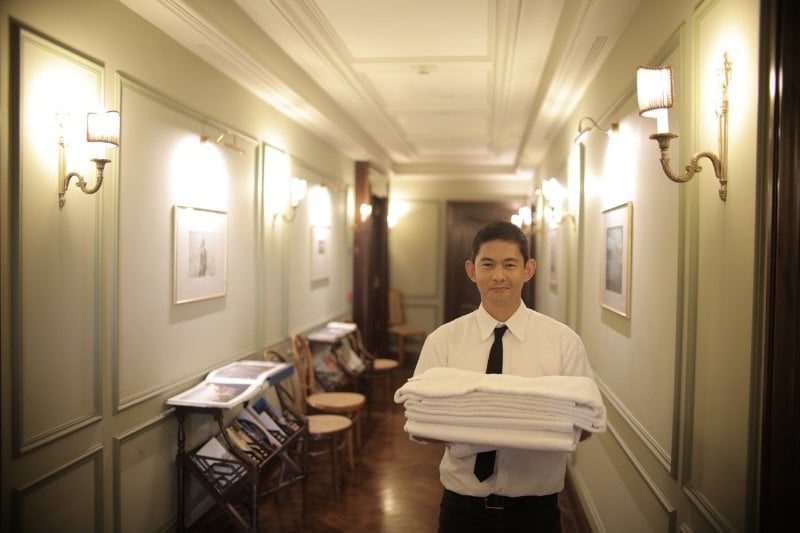 Hotel Worker Holding Bed Linens