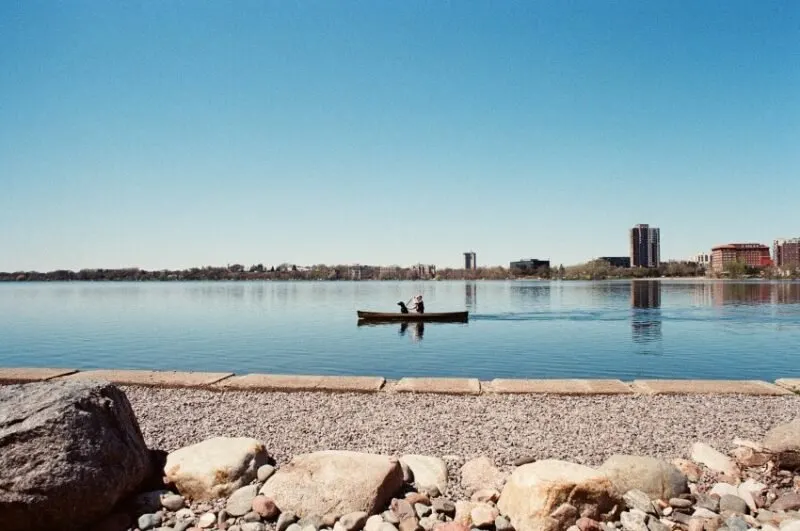 man kayaking Bde Maka Ska Minneapolis with skyline view